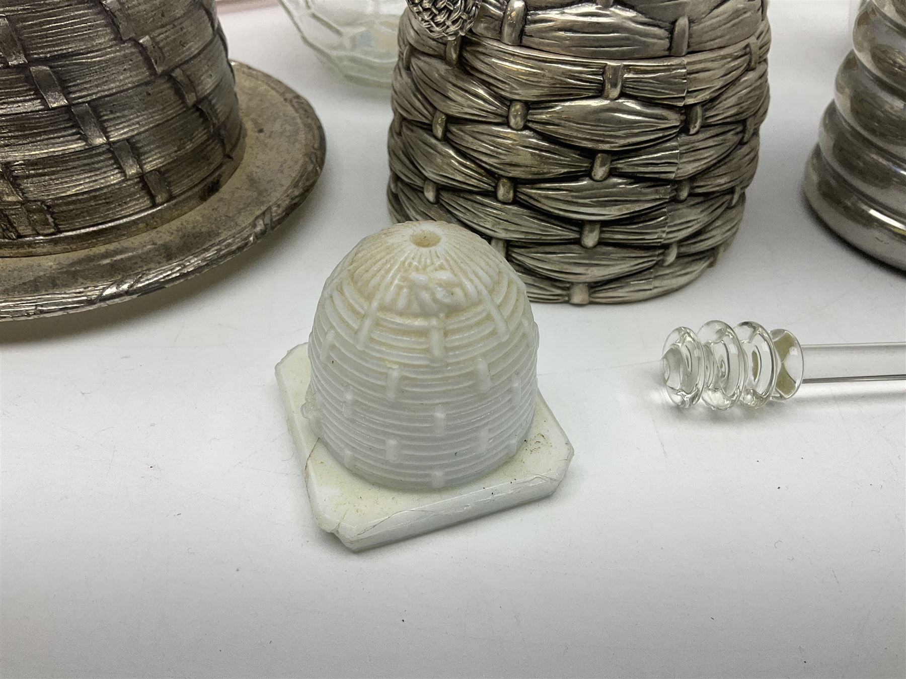 Collection of glass beehive honey pots, to include a blue slag example, milk glass, pink, green, etc together with four white metal examples (16) 