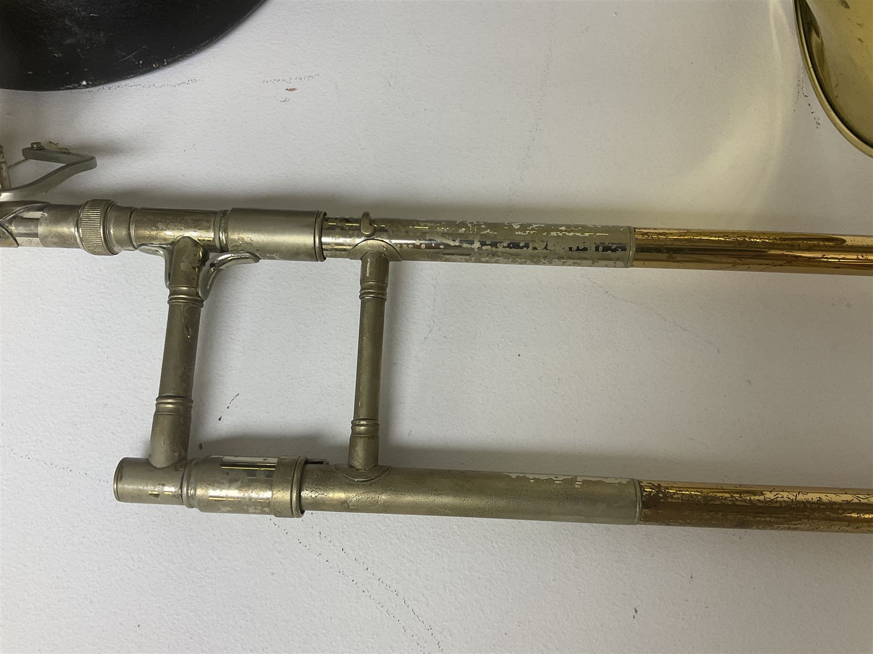 Three brass trombones comprising Elkhart Ind. USA 'CONN' model no.72H; Besson 'Concord'; and Selmer Distributed 'Lincoln'; two in carrying cases; and German B & M 'Champion' brass trumpet (4)