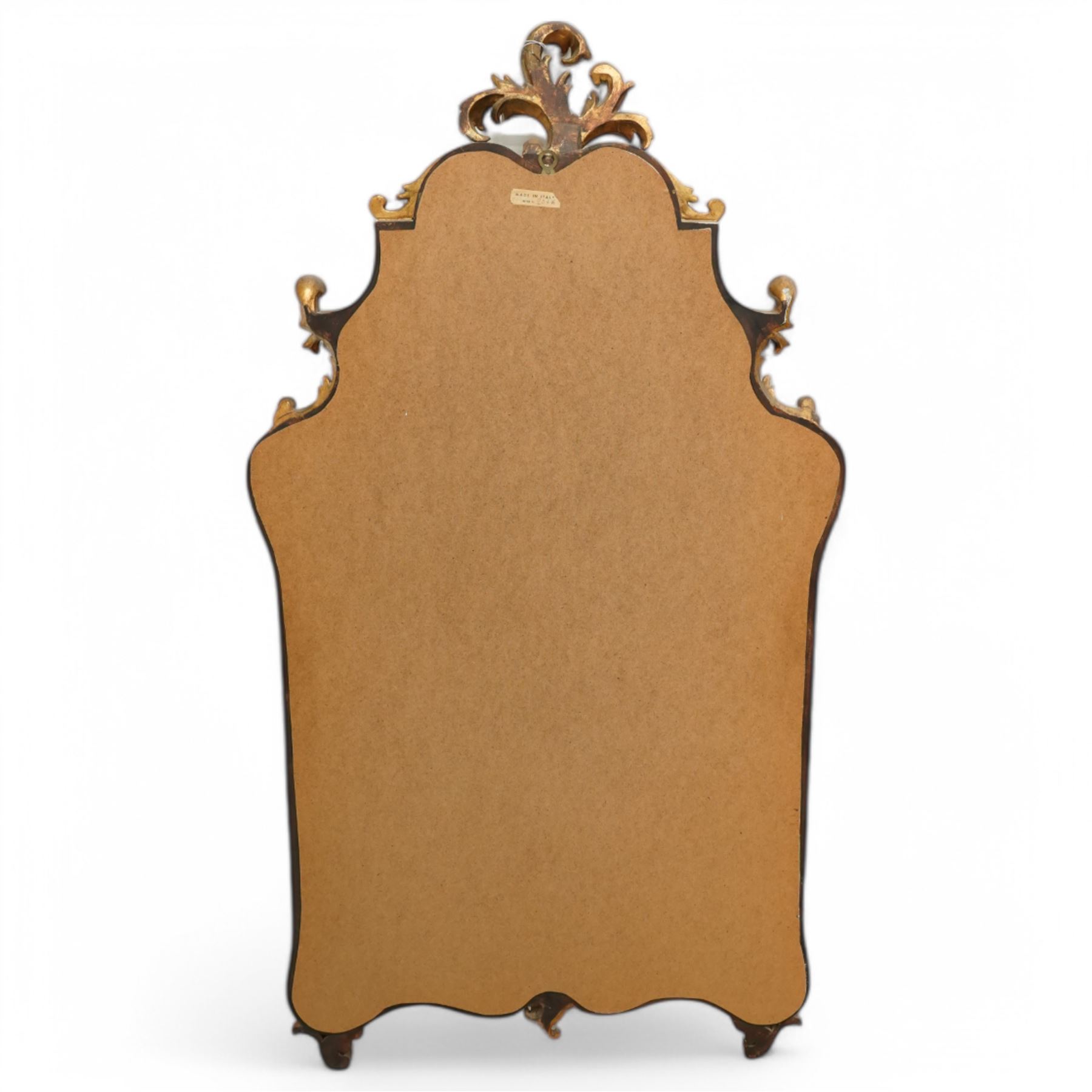 Rococo design carved gilt wood wall mirror, shaped and moulded frame decorated with scrolling leafage, plain mirror plate divided by mouldings