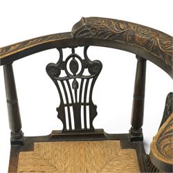 Pair of 19th century carved oak corner chairs, cresting rail carved with central floral bouquet with trailing foliage extending to the scroll arm terminals, pierced back splats with rosette motifs over drop-in rush seats, front cabriole support with acanthus carved knee and ball-and-claw foot