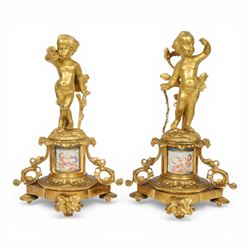 Pair of 19th century ormolu putto figures, each modelled stood with foliate support to bac...