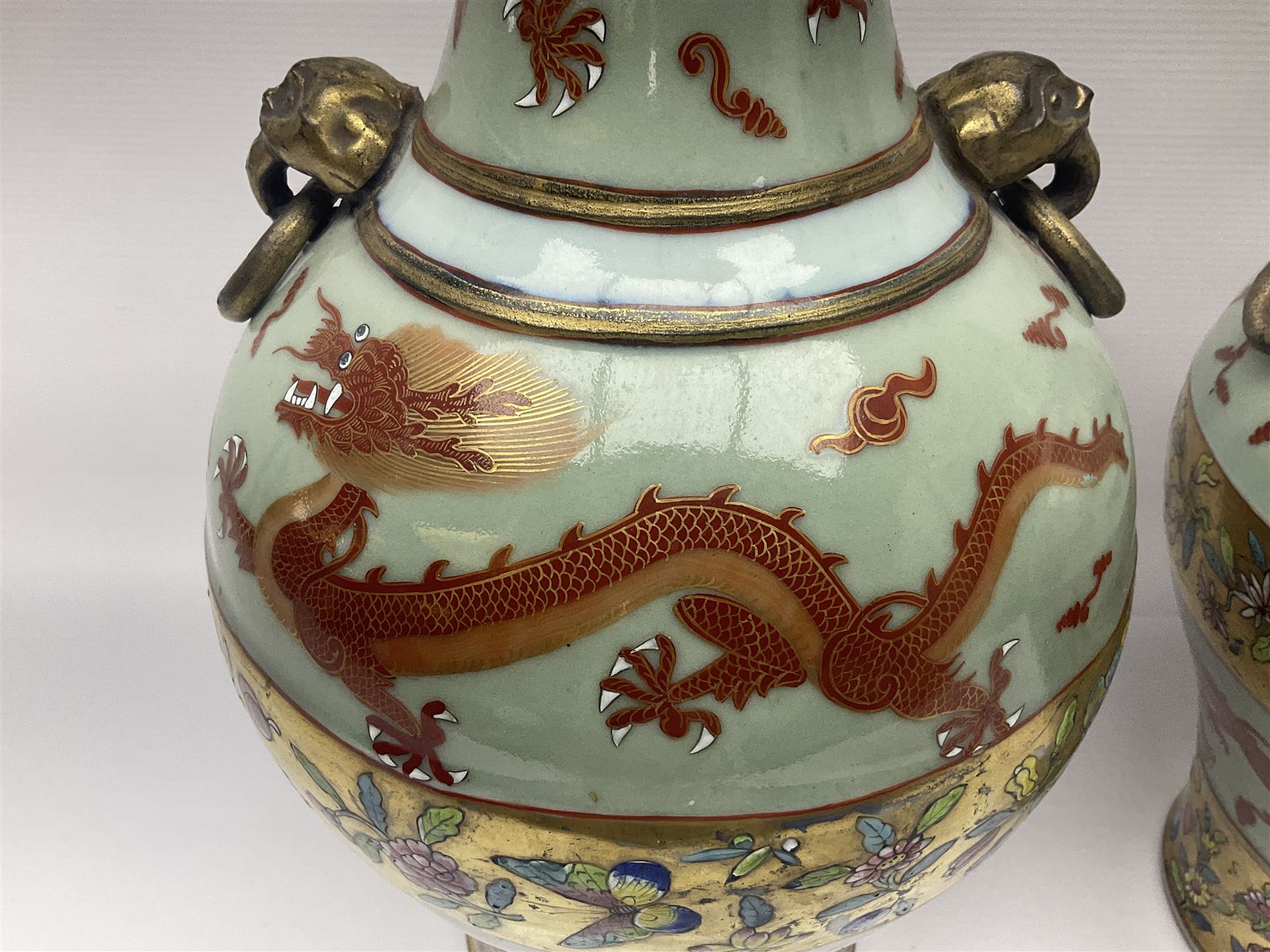 Pair of early 20th century Chinese vases decorated with dragons chasing a flaming pearl, with a gilt border of butterflies and floral sprigs, with Elephant head handles, H44cm 