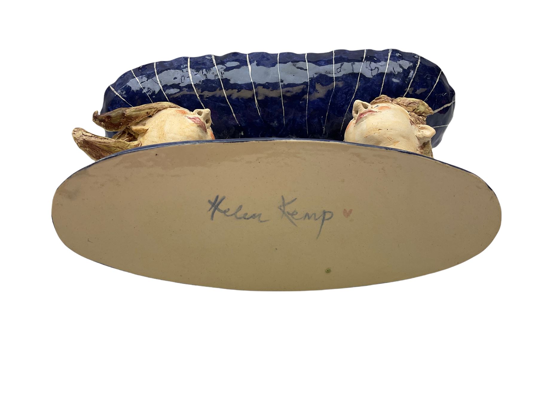 Ceramic 'girl and boy dish', by Helen Kemp, an oval dish with a mottled pink ground and gilt edging upon the sculpted heads of a girl and a boy, together with a 'boy sconce', by Helen Kemp, a sculpted boy holding a small bowl with foliate decoration, both with the artist's mark beneath.