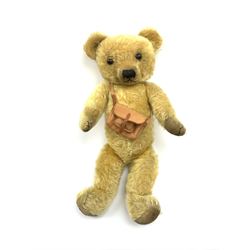 Merrythought Hygienic Toys large 'Magnet' teddy bear c1930s with plush body, swivel jointed head with glass eyes and vertically stitched nose and mouth and jointed limbs,  celluloid wishbone button to right ear and stitched label under right pad H22