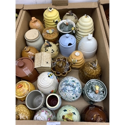 A large collection of various ceramic honey pots, to include examples in the form of bee skeps, etc.