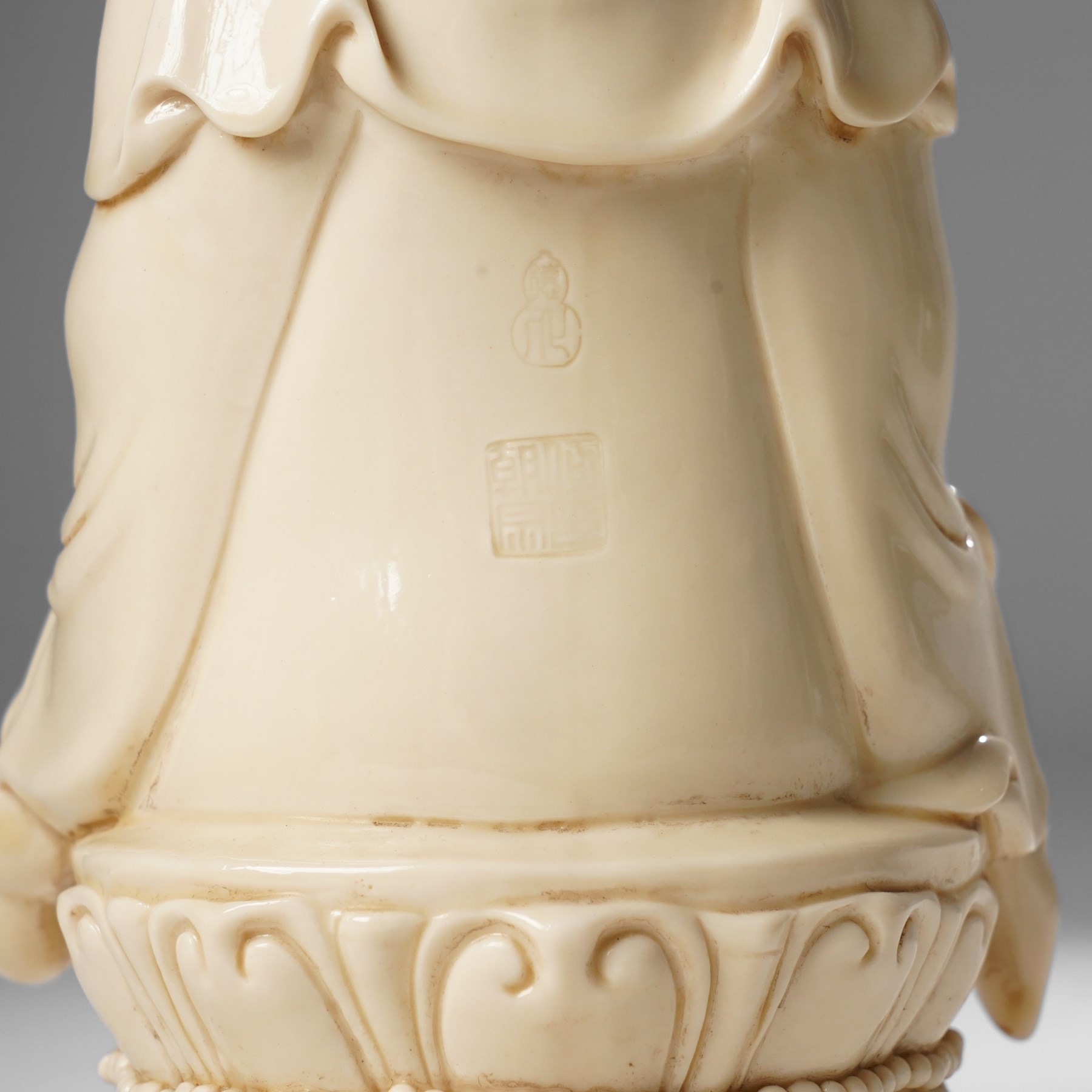 Three Chinese blanc de chine figures, each depicting Guanyin seated, Dehua province, two with double gourd and potters seal marks to the reverse 