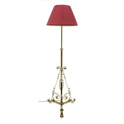 Early 20th century brass standard lamp, telescopic stem with three splayed supports, scroll work to the base, H180cm (max height once fully extended, measurement excludes shade and fitting)