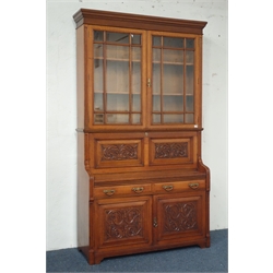  Edwardian golden oak secretaire bookcase, projecting cornice above two astragal glazed doors with bevelled glass, panelled fall front relief carved with scrolled foliate, interior well fitted with pigeon holes, sloped correspondence stand, drawers and leather writing surface, two drawers and panelled cupboard below, W137cm, H238cm, D45cm  