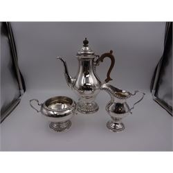 Mid 20th century three piece silver coffee service, comprising coffee pot, milk jug and twin handled open sucrier, of waisted form upon circular domed foot,  with oblique gadrooned rim, the milk jug and sucrier with acanthus capped handles, the coffee pot with wooden handle and finial, hallmarked William Comyns & Sons Ltd , London 1961, coffee pot H27.5cm
