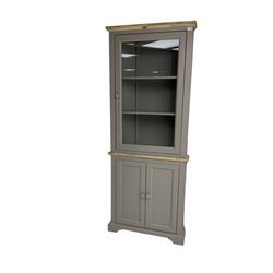 Contemporary teal and oak finish corner cabinet, single glazed door enclosing two shelves, over two panelled cupboard doors