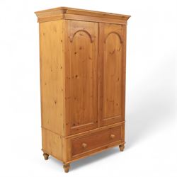 Two contemporary traditional-style wardrobes, projecting plain cornice above two arched moulded panel doors, above a full-width drawer fitted with turned wooden handles, raised on turned bun feet