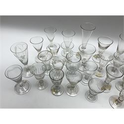 A large group of 18th and 19th century, and later in the style of drinking glasses, of various size and form, a number with engraved and etched decoration to bowls, and some with part fluted bowls.