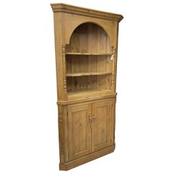 Waxed pine floor standing corner cupboard, projecting cornice over two open shelves flanked by turned uprights, base fitted with cupboard enclosing single shelf