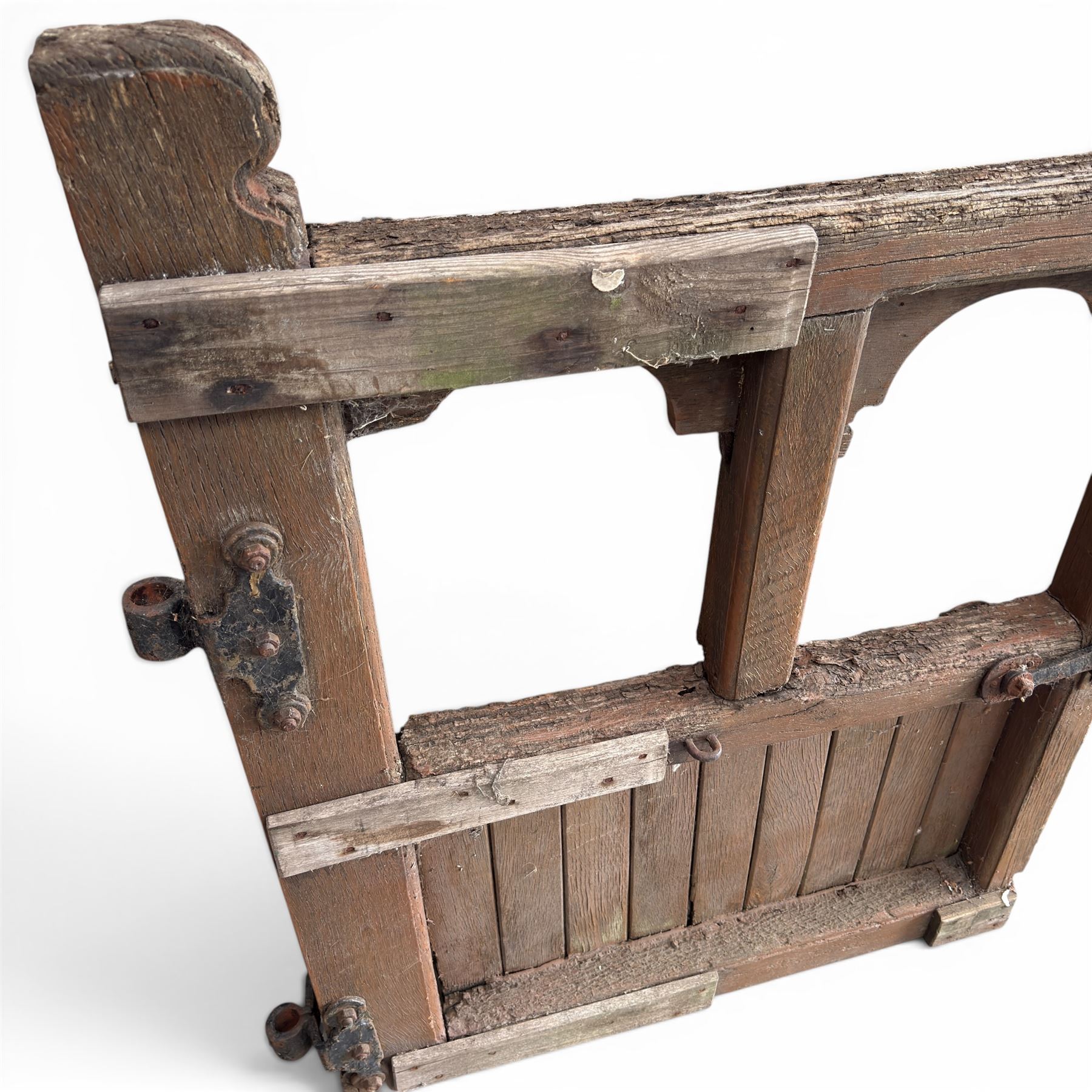 Pair of 19th century weathered wooden ecclesiastical church gates, the cresting rail over four pierced arches with slatted lower section, fitted with heavy cast iron hinges, latch and fittings