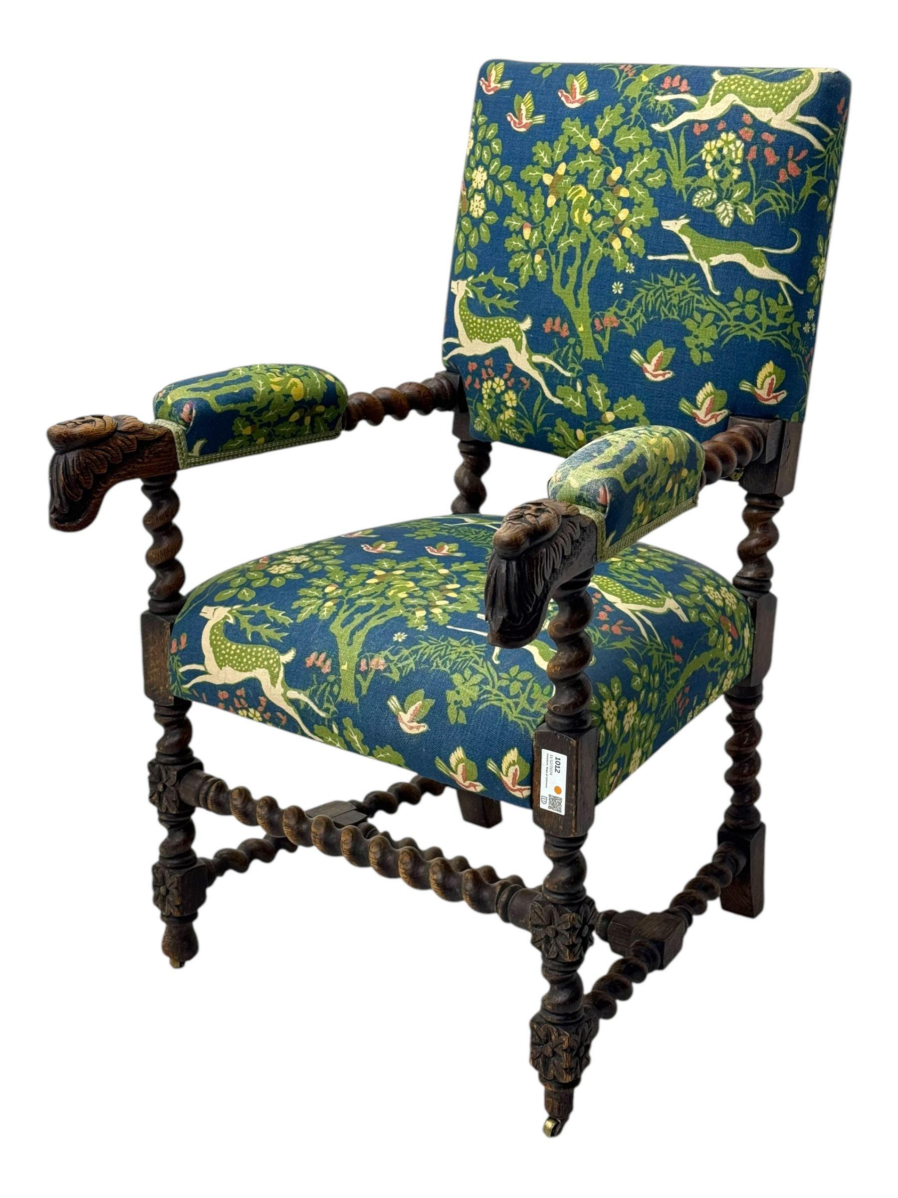 19th century Carolean design oak armchair, upholstered in a vibrant fabric depicting woodland and wildlife scenes, carved lion mask arm terminals, raised on barley twist supports united by H-stretcher