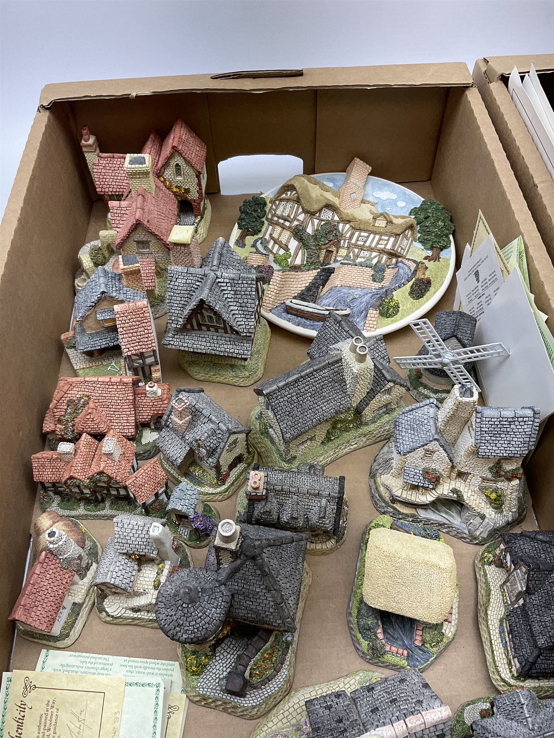 A collection of boxed David Winter cottages, of various size and form, to include Wreckers Cottage, Scottish Collection Macbeth's Castle, Special for Christmas 1988 Christmas in Scotland and Hogmanay, Special for Christmas 1990 Mister Fezziwig's Emporium, The Scrooge Family Home, Special for Christmas 1989 A Christmas Carol, The Midlands Collection Miners Row, Will-o-the wisp, etc., together with a plaque titled On the Riverbank, a number of examples with accompanying certificates. (30).