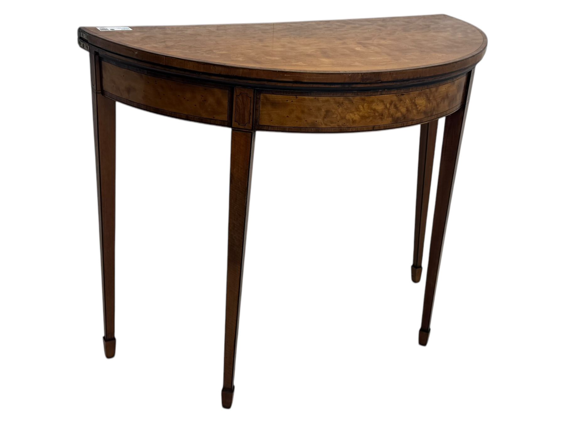 Edwardian satinwood inlaid demi-lune card table, hinged fold over green baize lined interior, raised on square tapered supports with spade feet  