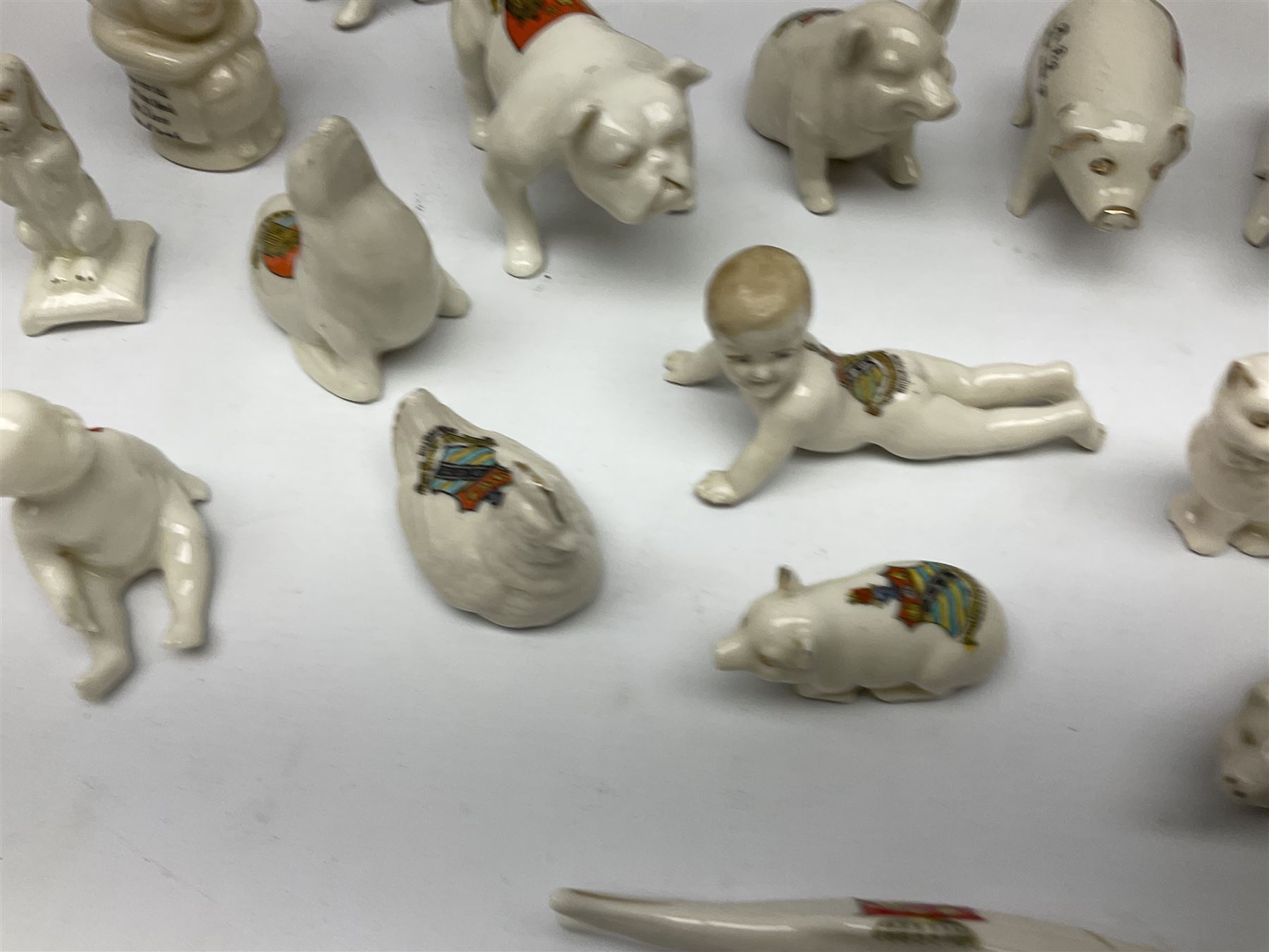 Collection of figural crested ware, to include Carlton Chins John Bull Alnwick, Clifton China Cheshire Cat,  Arcadia pig, Crafton crawling baby and another seated baby, quantity of cat, dog and pig figures, two Willow Art Model of Bunyans Statue, Toby jug, Victoria China, Arcadan bulldog, fish etc