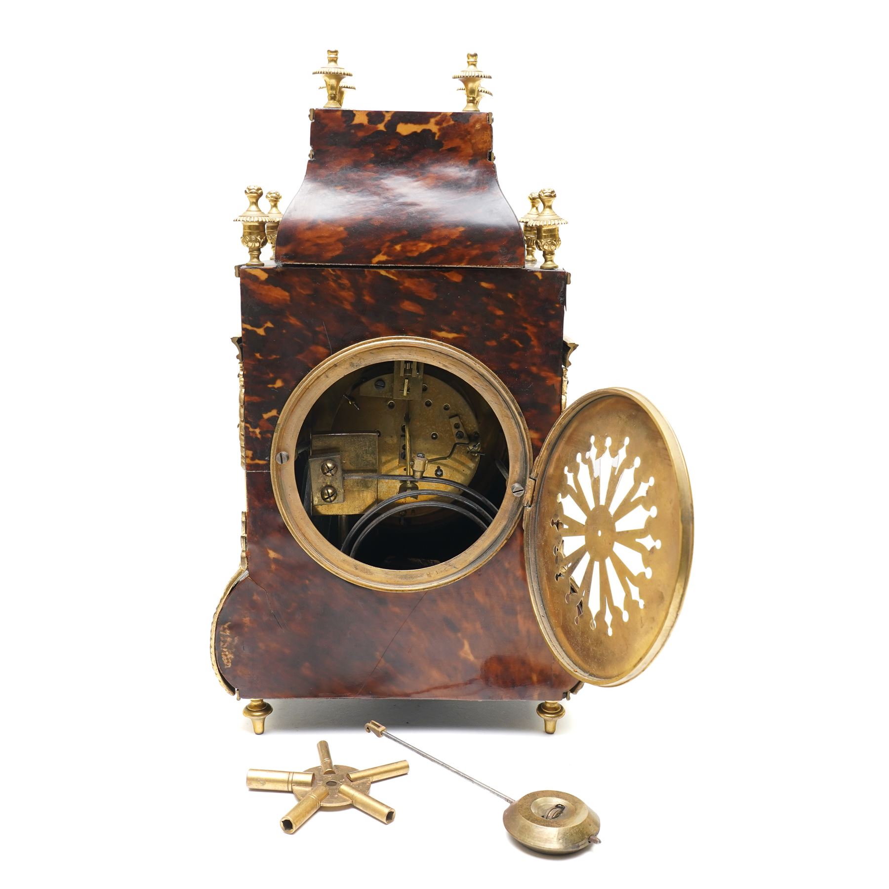 French-late 19th century brown stained 8-day faux Tortoise shell and ormolu mounted mantle clock, rectangular case with glazed side panels and shaped pediment with matching finials, convex enamel dial with Roman numerals, minute track and steel moon hands within a cast brass glazed dial bezel,
twin barrel movement with rack striking, striking the hours and half hour on a coiled gong. With pendulum and key.
