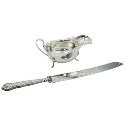 1930's silver sauce boat, of typical form with part shaped rim and curved handle, upon three pad feet, hallmarked Barker Brothers Silver Ltd, Birmingham 1936, together with a mid 20th century silver handled Queens pattern bread knife, hallmarked Viner's Ltd, Sheffield 1961, approximate gross weight 5.01 ozt (156 grams)