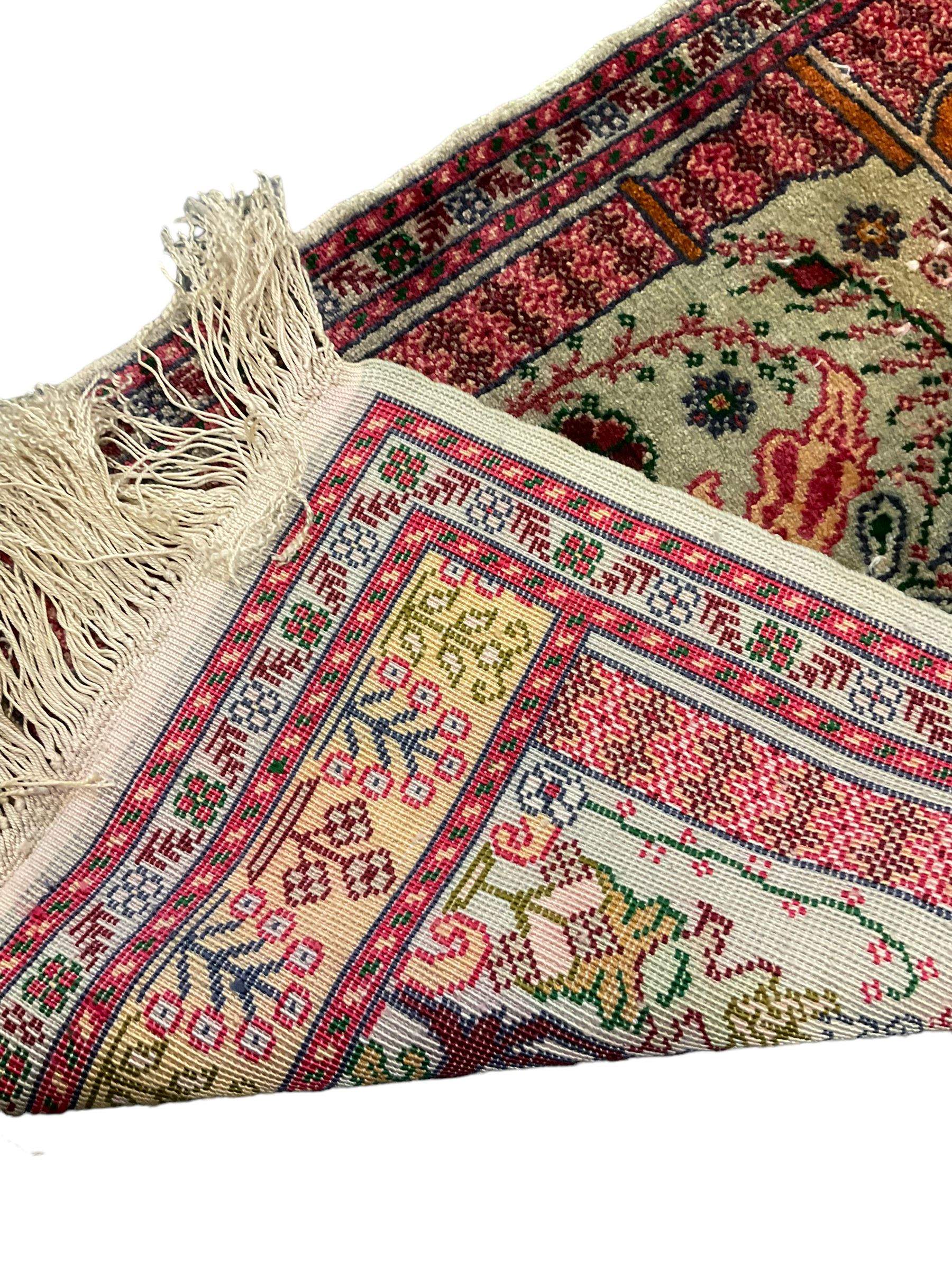 Small Persian magenta ground rug, central Mirab with flanking columns enclosing stylised urn motif with trailing foliage, the triple band border with plant motifs (86cm x 46cm); Persian red ground rug, two central floral medallions with extending flower heads, floral decorated border (106cm x 53cm) (2)