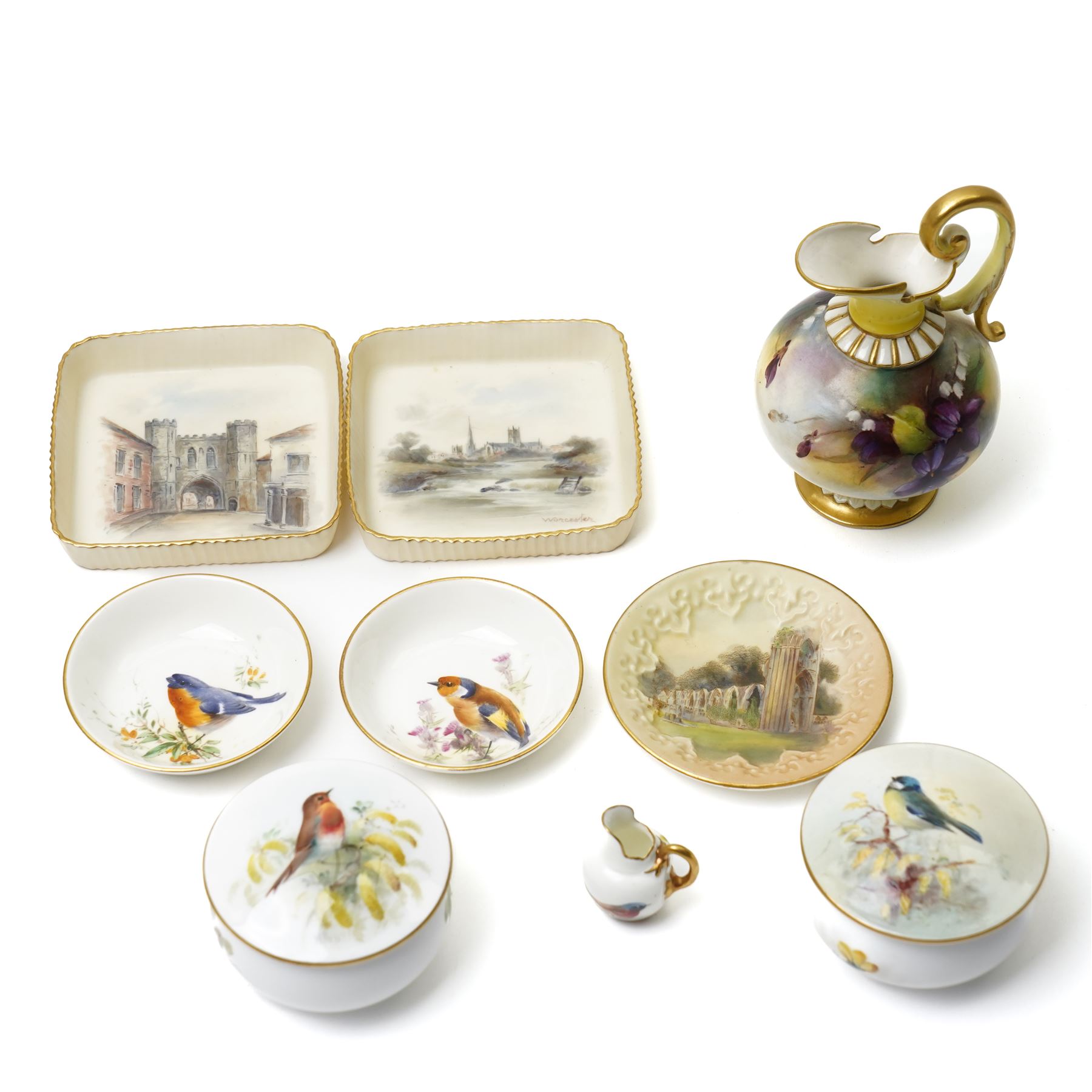 Nine hand-painted Royal Worcester items, comprising two trays painted with Worcester landscapes including 'Edgar Tower', a circular blush ivory tray painted with 'St Mary's Abbey - York', two trays and two covered trinket dishes painted with birds by Ernest Barker and H Powell, miniature jug painted by J Allen, and a Hadley Ware ewer, H11cm (9)