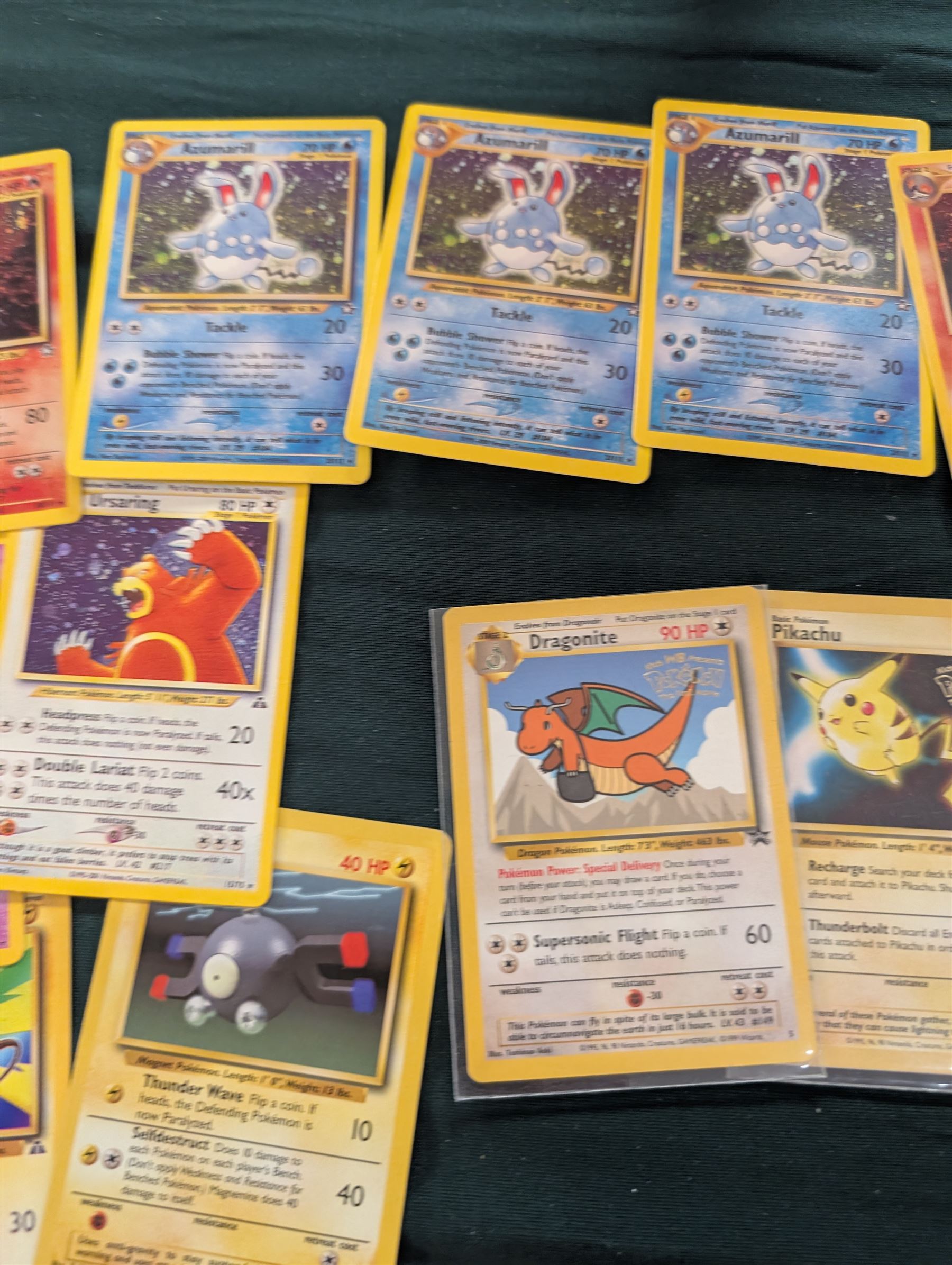 Collection of Pokemon TGC trading cards, including two WB First Movie Black Star promo cards Pikachu no. 4 and Dragonite no. 5, two Ancient Mew Black Star holo promo cards, Gym Challenge Giovanni's Persian 8/132 holo and a small collection WOTC, Neo Discovery and Neo Genesis cards, together with thirty four Bandai Carddass Pokemon cards, including prism Charizard no. 186 and Pokemon Topps cards including holo examples 