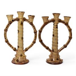 Pair of studio pottery candlesticks, with a central twisted column bordered by circular su...