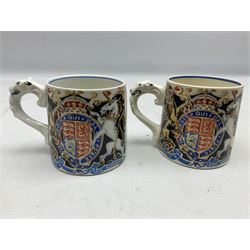 Two Dame Laura Knight coronation mugs for King George VI and Queen Elizabeth, comprising a Burleigh Ware example and a J&G Meakin example, each with a lion moulded handle and printed marks beneath, H8cm