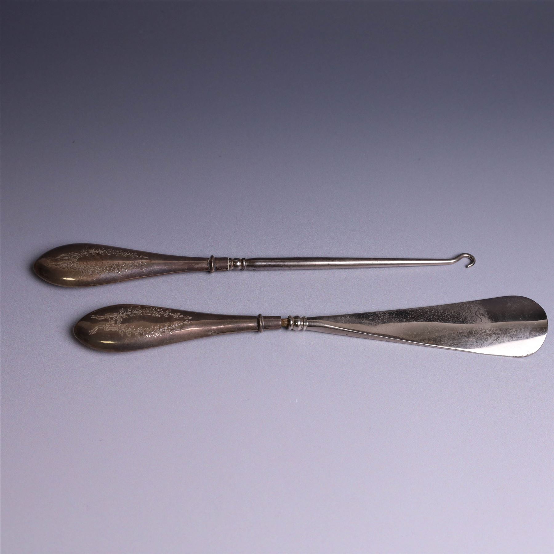Early 20th Century silver mounted dressing table set, comprising hand mirror, shoe horn and a button hook, each with engraved floral decoration, together with a silver mounted hairbrush and clothes brush, all hallmarked