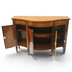 Quality handmade Sheraton Revival inlaid mahogany serpentine-front commode sideboard, shaped rectangular top with boxwood stringing, the banded frieze fitted with three drawers, over four matched-veneer cupboards with oval inlays and banding, raised on square tapering and turned feet with gadroon carving, retailed by David Hick Interiors, Jersey
