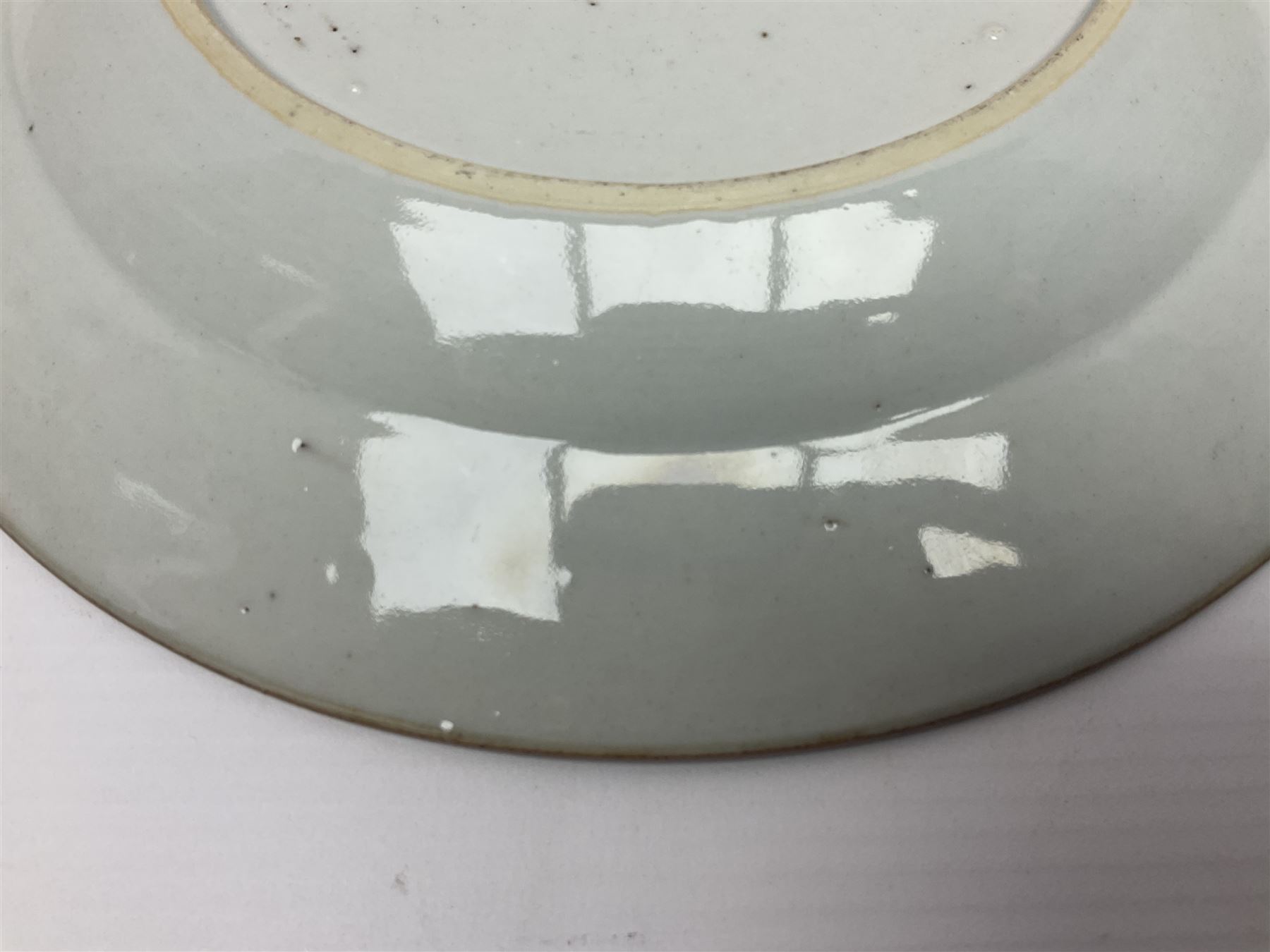 Three 18th century Chinese Famille Rose plates, the first example enamelled with blossoming peonies, rockwork and fence, the other two examples of similar design, decorated with blossoming peonies and sprigs within shaped inner borders, each approximately D23cm