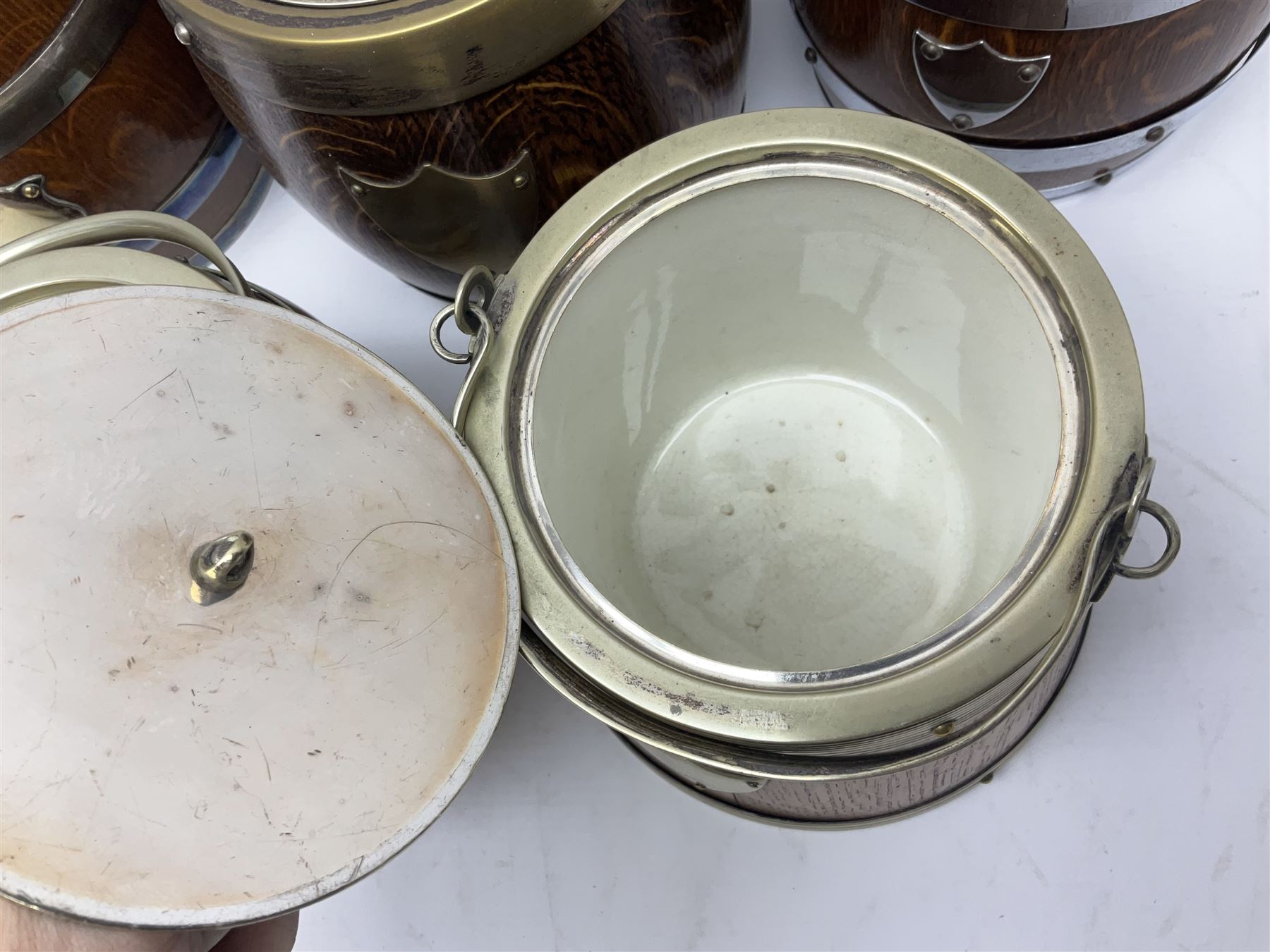 Five early 20th century biscuit barrels with silver-plated mounts