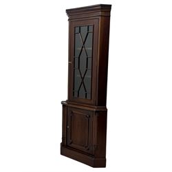 Late 20th century mahogany corner cabinet, dentil moulded cornice above a glazed door with astragal glazing enclosing two shelves, lower cupboard with fielded panel door and turned shell motif, on plinth base