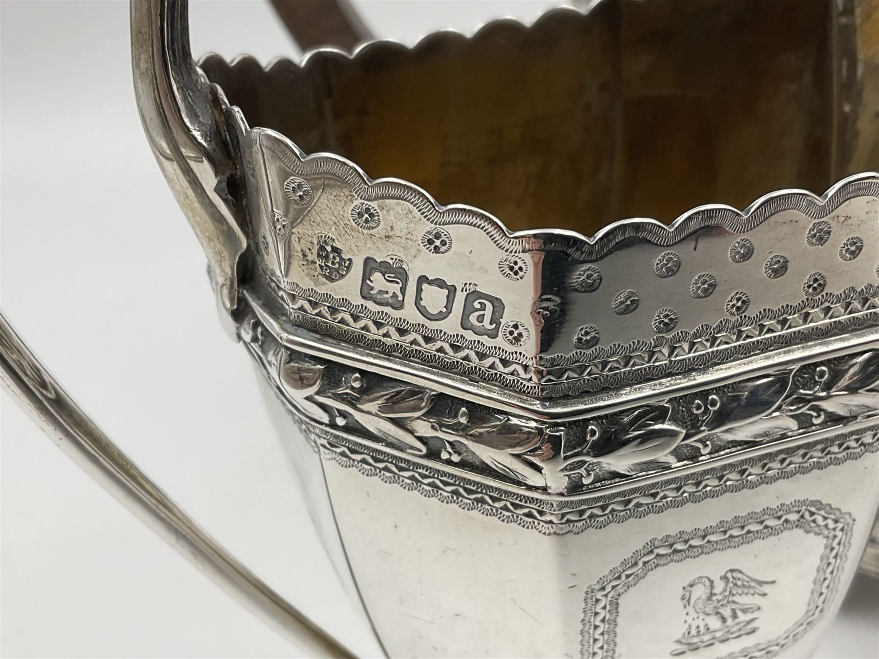 Victorian silver four piece tea service, comprising teapot, teapot stand, twin handled open sucrier and milk jug, each of octagonal form with foliate bud border and engraved decoration including crest to canted panels, and vacant panels, the teapot with ivory finial to the hinged cover and later wooden handle, hallmarked Edward Barnard & Sons Ltd, London1896, teapot including finial H15cm, milk jug including handle H16cm, teapot stand W11.5cm

This item has been registered for sale under Section 10 of the APHA Ivory Act