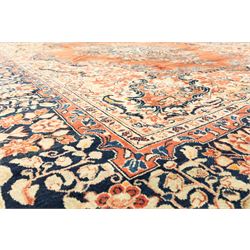 West-Central Persian Mahal hand-knotted carpet, terracotta field with a large central indigo and ivory medallion with floral palmettes and scrolling vines, framed by ivory spandrels with dense foliage within a broad navy border of lotus and palmette motifs linked by scrolling tendrils and multiple guard stripes 