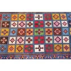 Persian Gabbeh indigo ground runner rug of garden design, the multi-coloured field decorated with five columns of panels in contrasting colours with stylised plant motifs, the guard band with trailing foliage