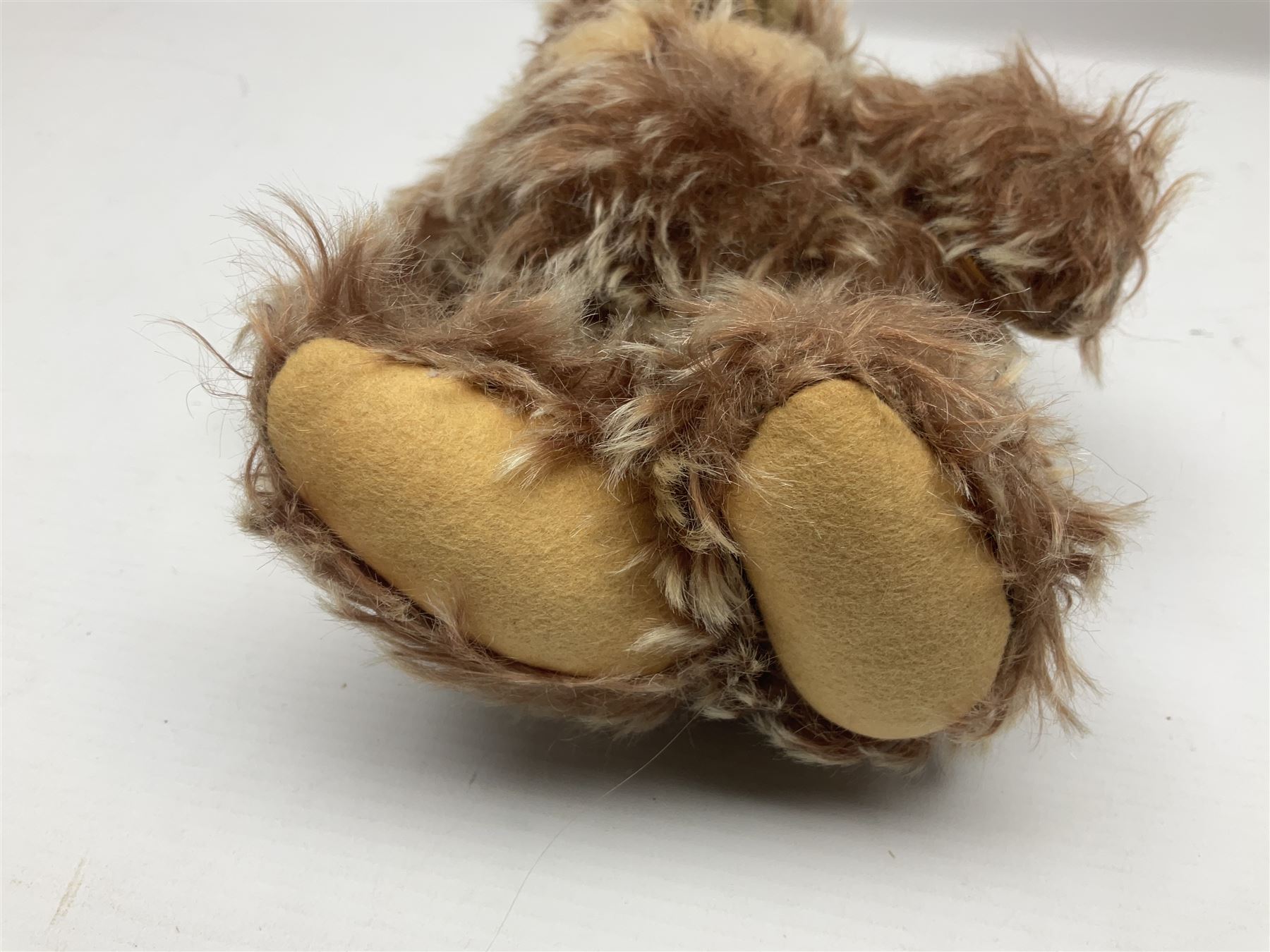 Steiff teddy bear with golden plush body, revolving head, applied eyes, vertically stitched nose and mouth and jointed limbs; button to left ear H26cm; and two other Steiff teddy bears, each with open mouth and button with tag to left ear (3)
