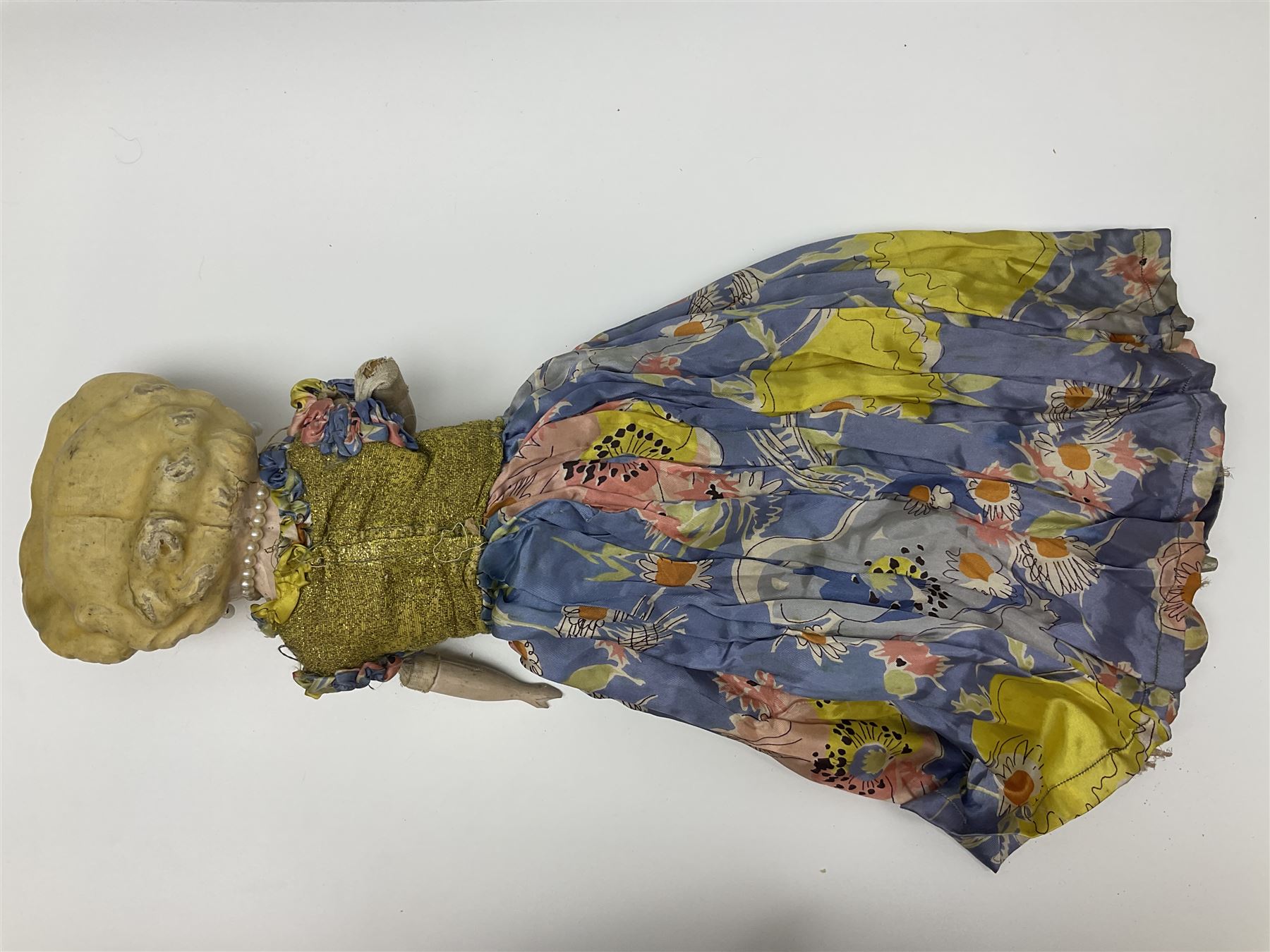 Victorian large wax over composition Pumpkin head doll, with inset dark glass eyes, moulded blonde hair in curls, stuffed body with carved and painted wooden limbs, grey painted boots, floral satin dress with netting underclothes H61cm