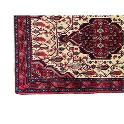 North West Persian Saveh crimson ground runner rug, the three lozenge pole medallions in an ivory field, surrounded by stylised plant motifs, the guarded border decorated with repeating geometric patterns
