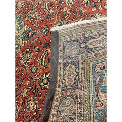 Persian Sarouk rug, red and blue ground, the field decorated with scrolling foliate and stylised plant motifs, the border decorated with floral panels