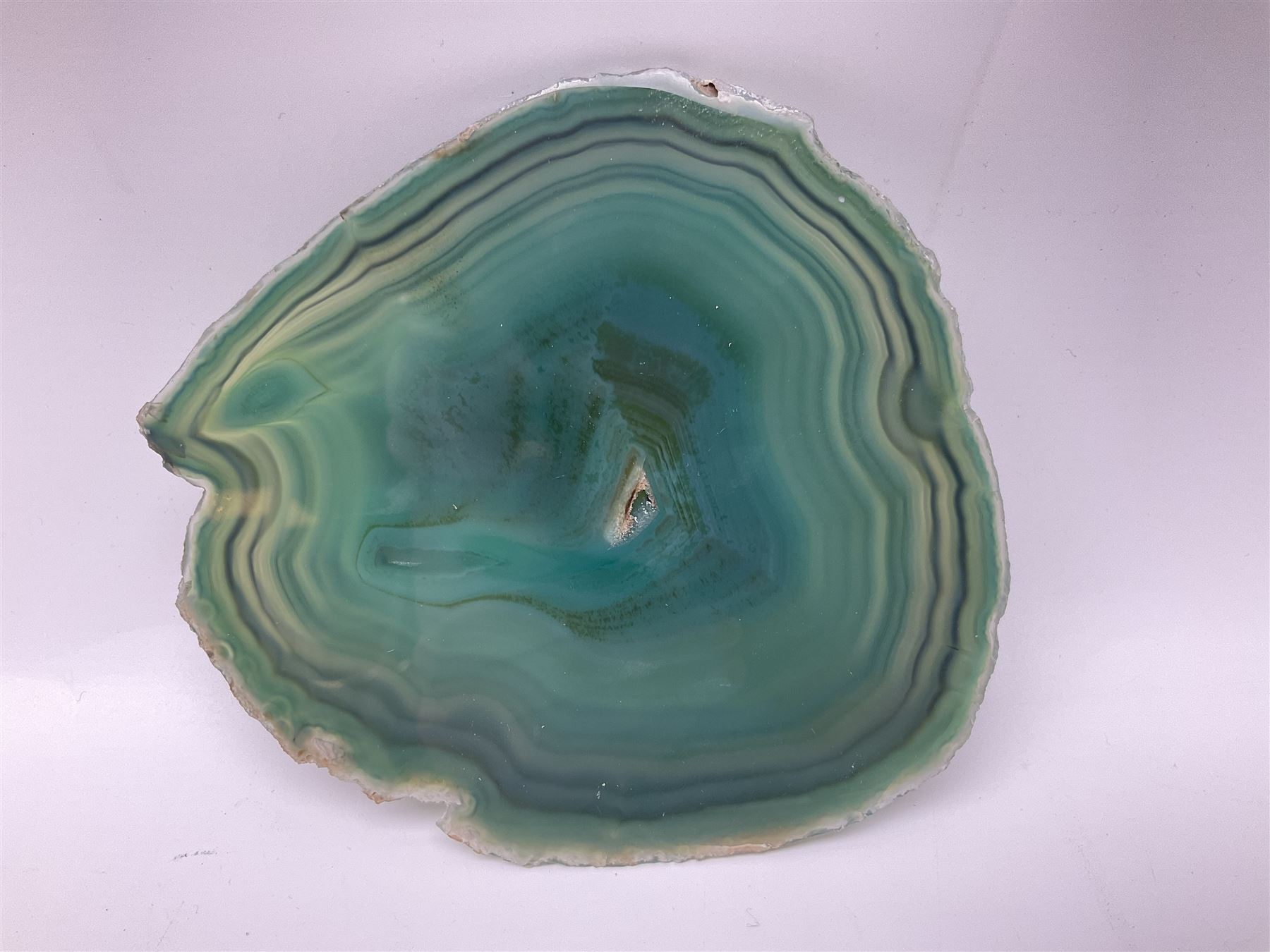 Pair of green agate slices, polished with rough edges, raised upon silvered metal stands, H23cm