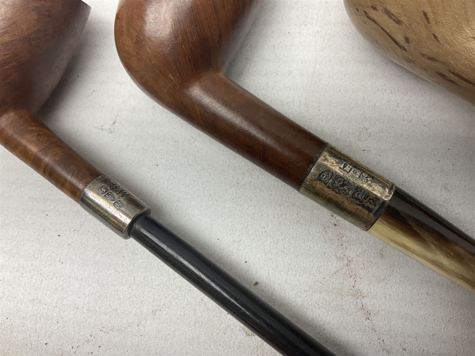 Collection of eight silver mounted pipes, comprising a briar wood Imperial ITC example with silver collar hallmarked A.W Birmingham 1903, horn handled example with silver collar hallmarked LB, probably Louis Blumfeld, Birmingham 1900, three examples marked B.W, one marked Globe A.O.C, Blumfeld's Best Briar pipe marked BBB and Riseagle example, together with two further pipes (10)