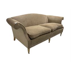 Traditional three seat sofa, curved back over scrolled arms, upholstered in crushed beige fabric with matching loose cushions, on turned front supports with brass and ceramic castors, together with matching footstool