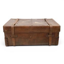 19th century leather trunk, featuring brass lock, with leather anchoring straps around the body, with leather handles