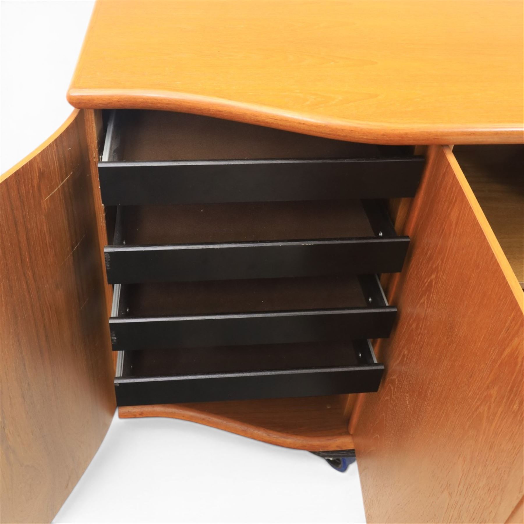 Skovby - model '400T' teak sideboard, shaped top above three cupboard doors with recessed handles, fitted with shelving and drawers