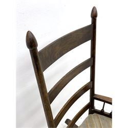 William Birch for Liberty & Co. - Arts and Crafts period oak ladder back rocking chair, the arms supported by a series of turned spindles, upholstered seat