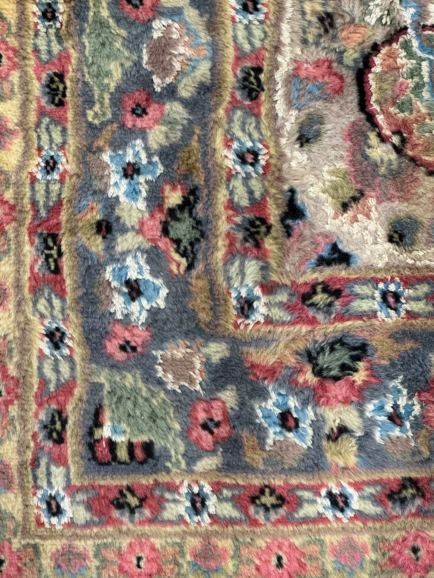 Persian design ivory ground rug, overall floral design with shaped central medallion, the main border decorated with trailing flower head pattern, within guard stipes 