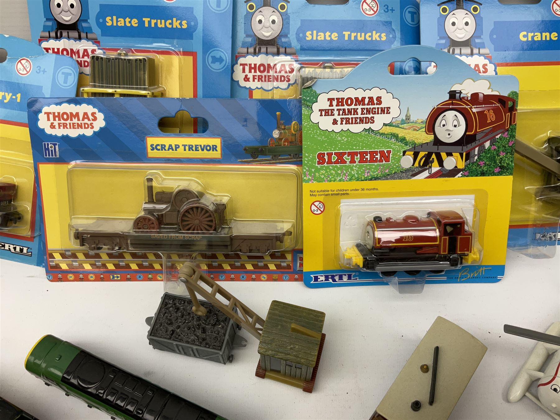 Ertl Thomas the Tank Engine and Friends die-cast models including carded Scrap Trevor, Slate Trucks, Neil, Wilbert, Sodor Taxi, Sodor Recovery Unit, Crane and four key rings; together with various uncarded models including locomotives, coal wagons, steam rollers, boat transporter, recovery units etc (over forty items)