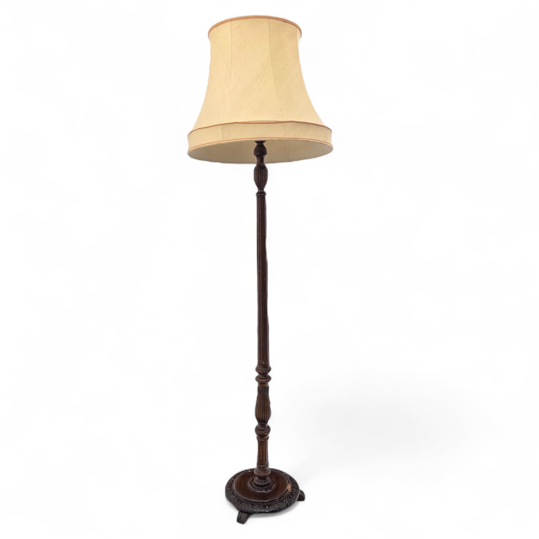 20th century mahogany floor lamp, the reeded column with carved urn knop on circular foliate moulded base, with cream fabric shade